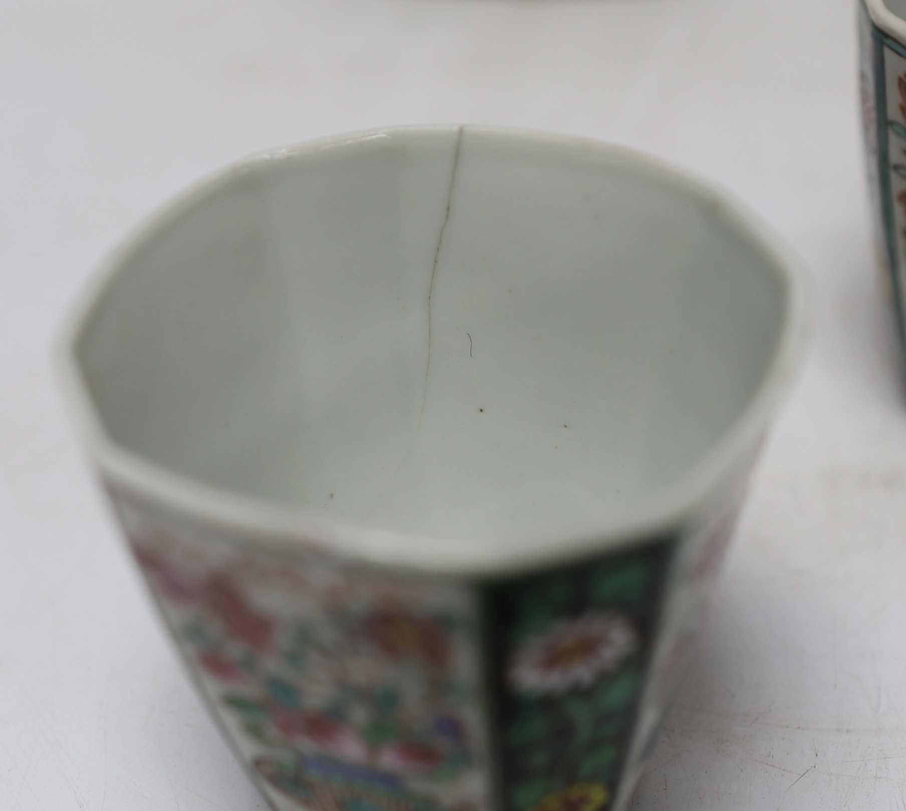 A pair of Chinese Qianlong famille rose octagonal cups and saucers, with panelled floral decoration, saucers 12cm cups height 6.5cm diameter 6.75cm
